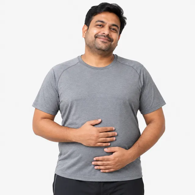 A smiling man in a gray T-shirt with his hands resting on his stomach