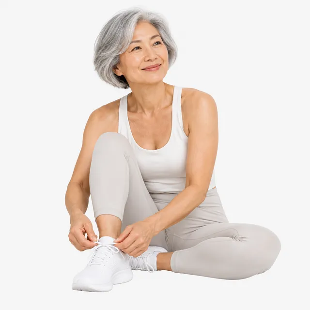 A smiling woman with silver hair tying her trainers