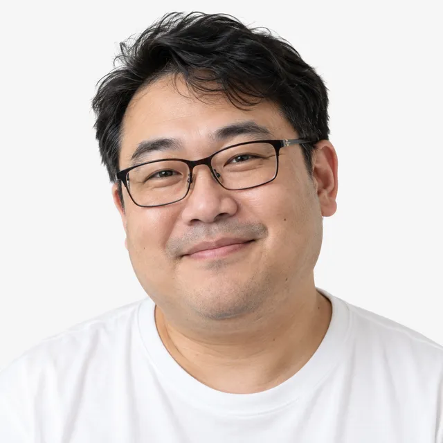 A smiling man in glasses and a white T-shirt