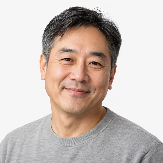A smiling man with salt-and-pepper hair in a gray sweater