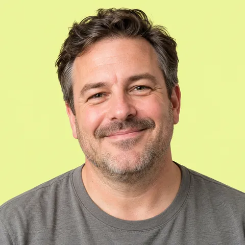 A smiling man with a short beard in a gray T-shirt