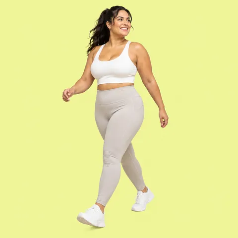 A smiling woman with long dark hair walking in activewear